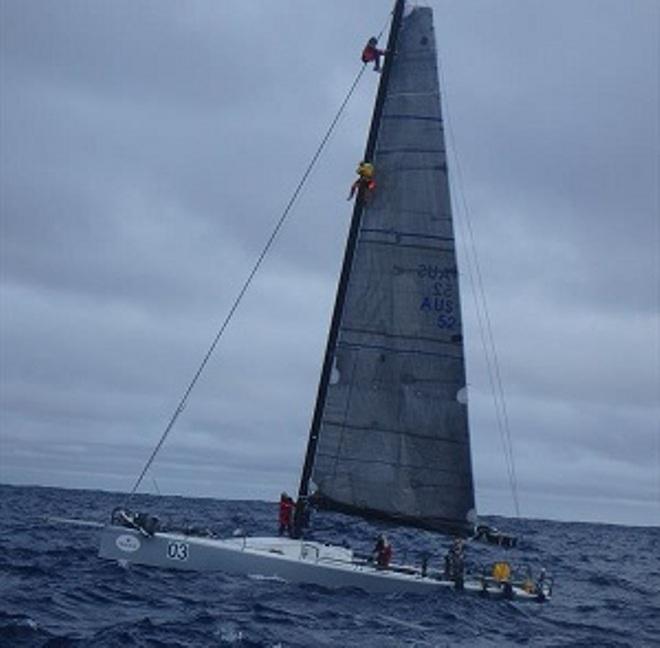The stricken TP52, M3, with Gavin going up the mast to help the entangled crewman. ©  Ocean Cruising Club