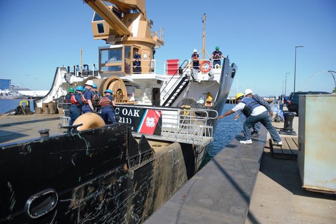 Coast Guard cutter Oak crew members pull the brow onto the ship in order to crew to deploy down south on Sunday, Sept. 10, 2017, in Newport, Rhode Island. The cutter deployed to assist in revitilizing the waterways in wake of Hurricane Irma. © Petty Officer 3rd Class Nicole J. Groll