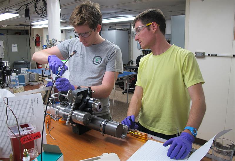 Jesse McNichol (left, with former WHOI postdoc François Thomas) and colleagues conducted experiments on samples of vent fluids collected in Isobaric Gas-Tight cylinders photo copyright Jennifer Barone, Woods Hole Oceanographic Institution taken at  and featuring the Cruising Yacht class