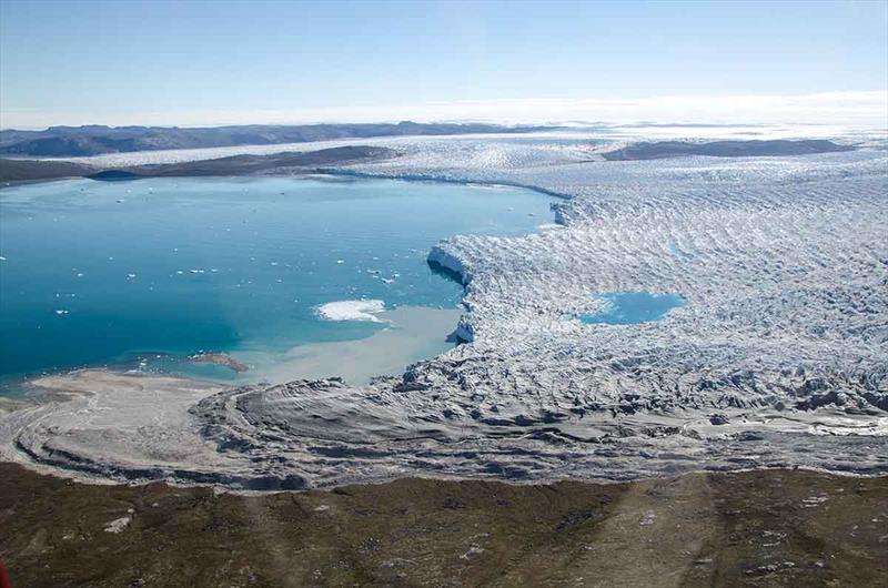A large tidewater glacier meets the coast in west Greenland, spilling ice and meltwater into the ocean.  - photo © Sarah Das, Woods Hole Oceanographic Institution
