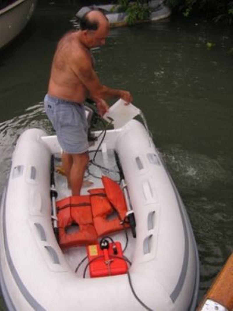 Gas can locked in dinghy, David's Bailing a tropical downpour photo copyright Commuter Cruiser taken at 