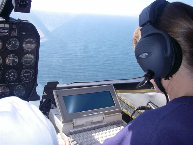 Research biologist Karin Forney of the Southwest Fisheries Science Center enters survey data into a computer aboard the airplane photo copyright Scott Benson / NOAA Fisheries taken at 