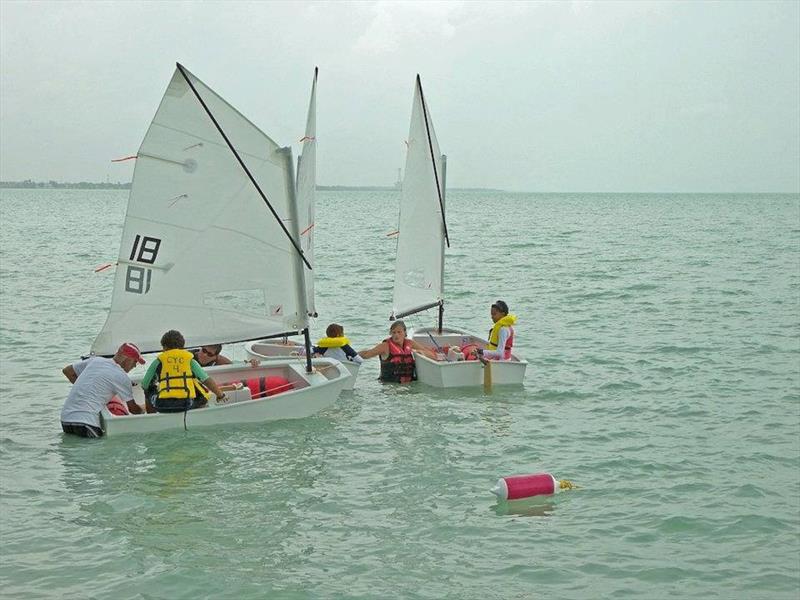 Libby and Gerard working with young sailors in Corozal Bay photo copyright Corozal Bay Sailing Club taken at Corozal Bay Sailing Club and featuring the Optimist class